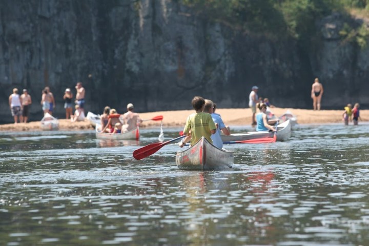 a group of people riding on the back of a boat in the water