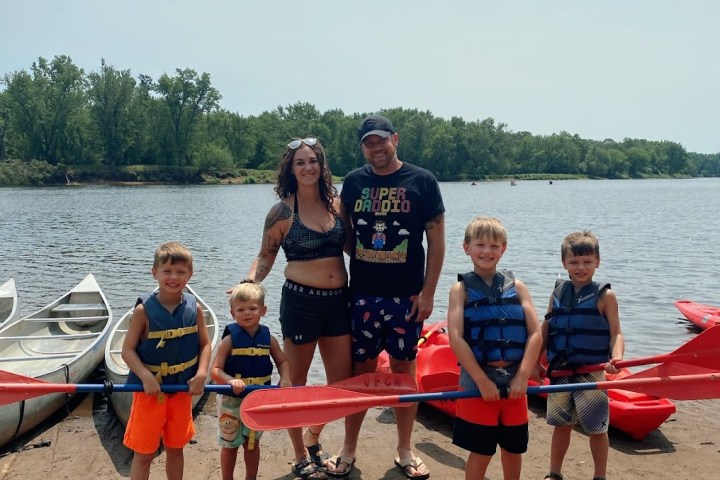 a group of people standing next to a body of water