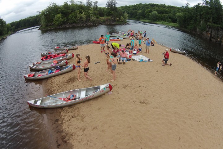 a group of people on a beach near a body of water