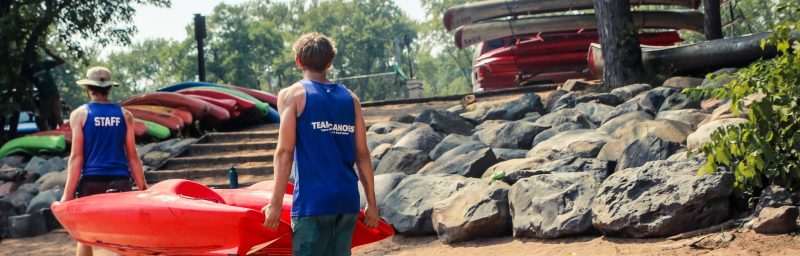 a young boy standing on a rock