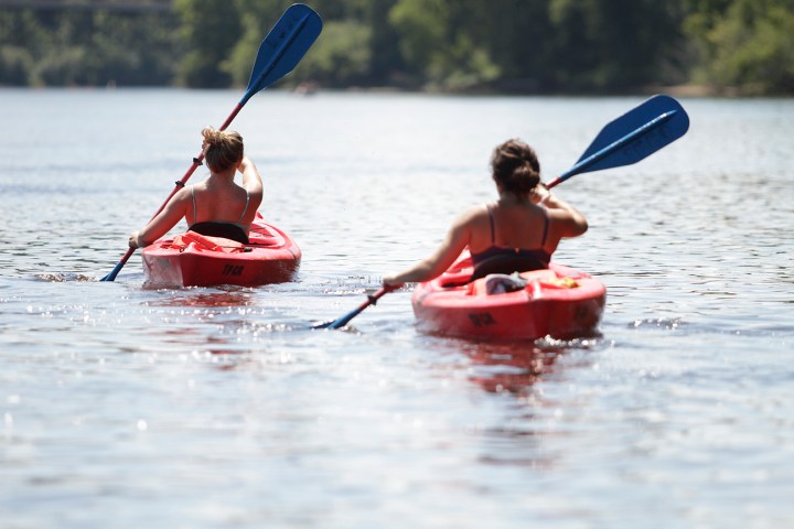 a group of people rowing a boat in a body of water