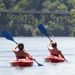 a group of people rowing a boat in a body of water