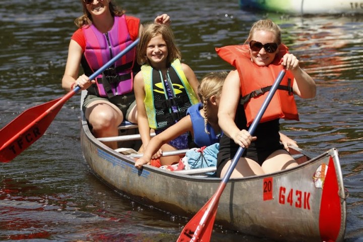 a group of people in a small boat in a body of water