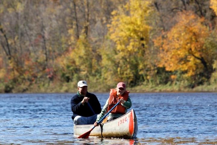 a man riding on the back of a boat in the water