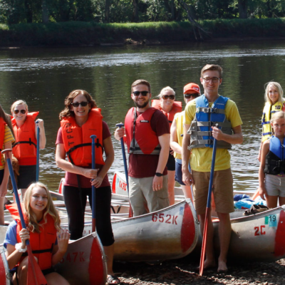 a group of people standing next to a body of water