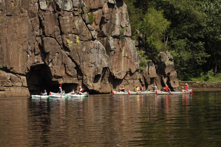 a group of people standing next to a body of water