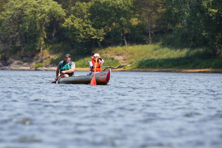 a man riding on the back of a boat in the water
