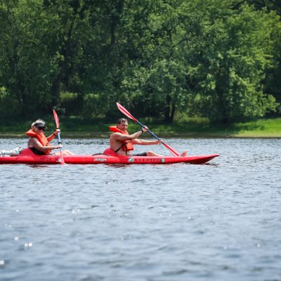 a group of people rowing a small boat in a body of water