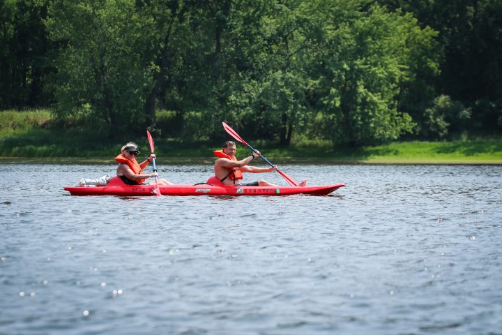 a group of people rowing a small boat in a body of water